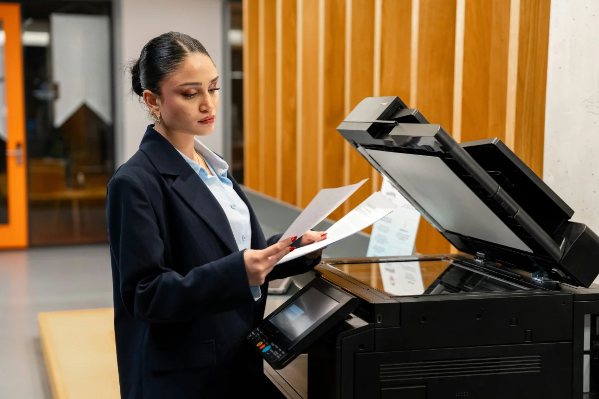 Woman reading paper copies at a photocopier